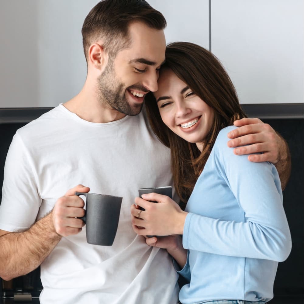 An adult man is laughing, showing off a set of braces.